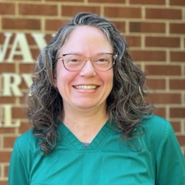 Dr Amber Meade posing for a picture outdoors in front of a brick wall
