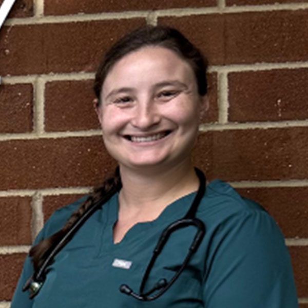 Dr Jessica Hartz posing for a picture outdoors in front of a brick wall